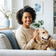 A diverse, smiling person posing for a professional headshot in a bright, modern room with light blue accents.